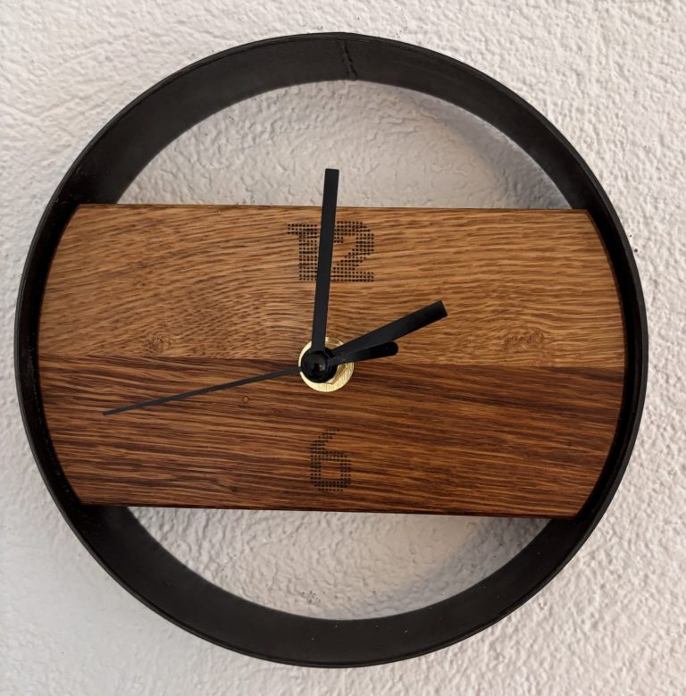 Handgefertigte Wanduhr aus Holz mit schwarzem Stahlrahmen und Ziffern 6 und 12